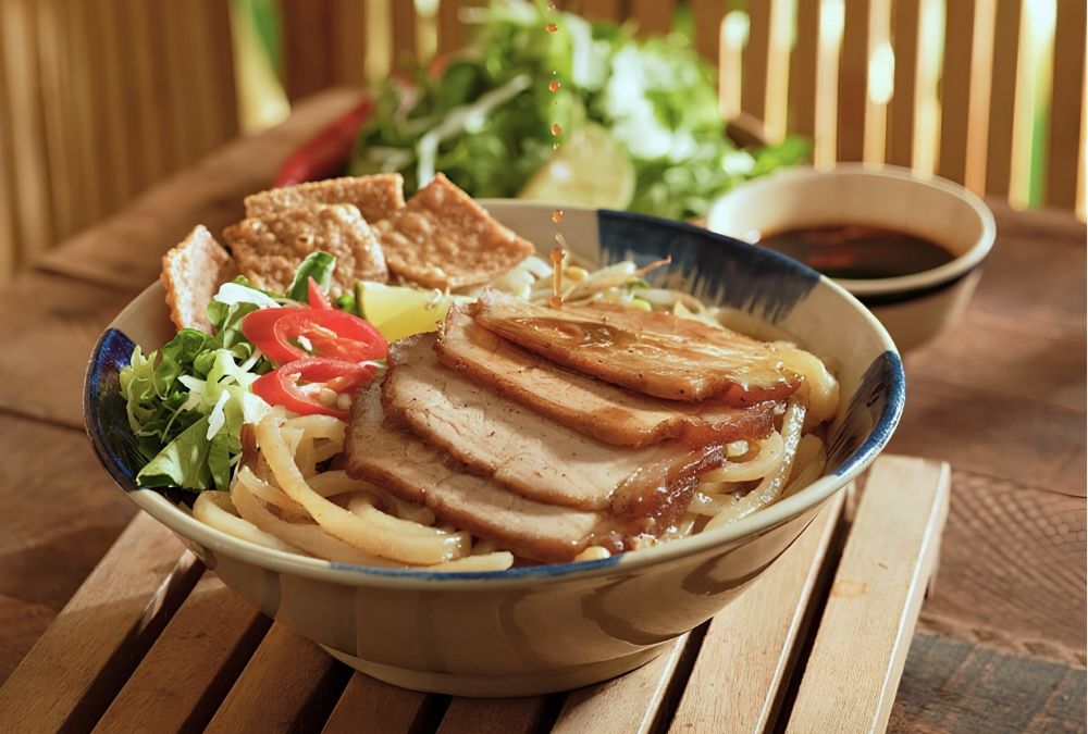 Mixing Cao Lau noodles with pork, fresh herbs and sauce before eating (Source: Da Nang Fantasticity)