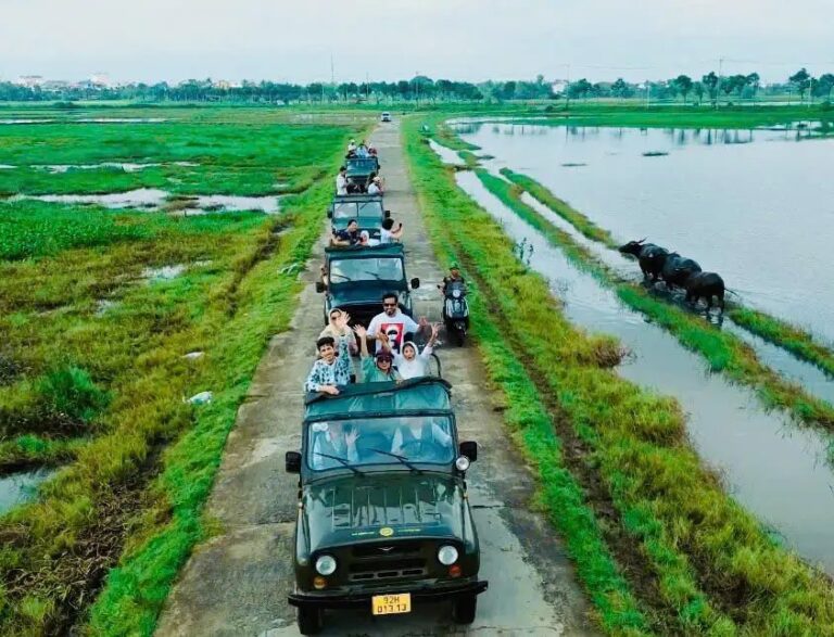 Army jeeps on a country lane through rice paddies near Hoi An